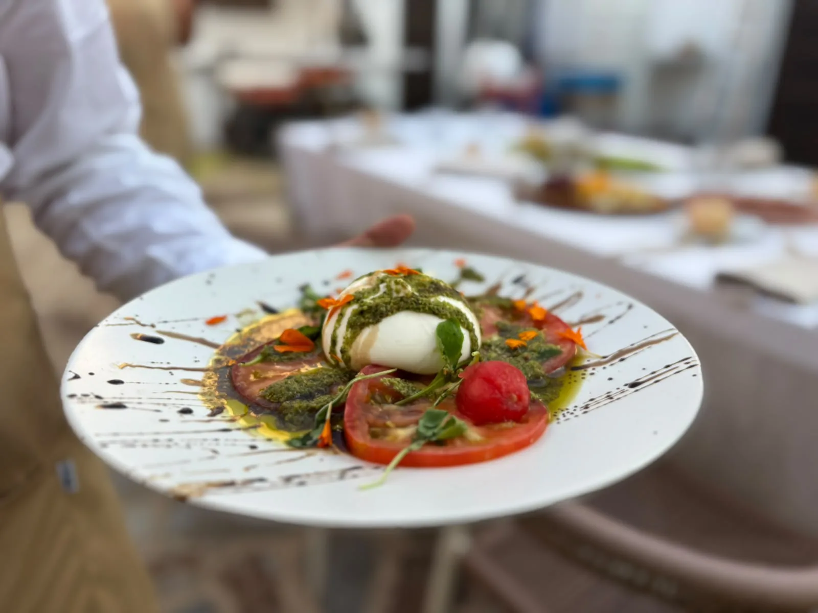 Servicio en mesa de burrata con tomate