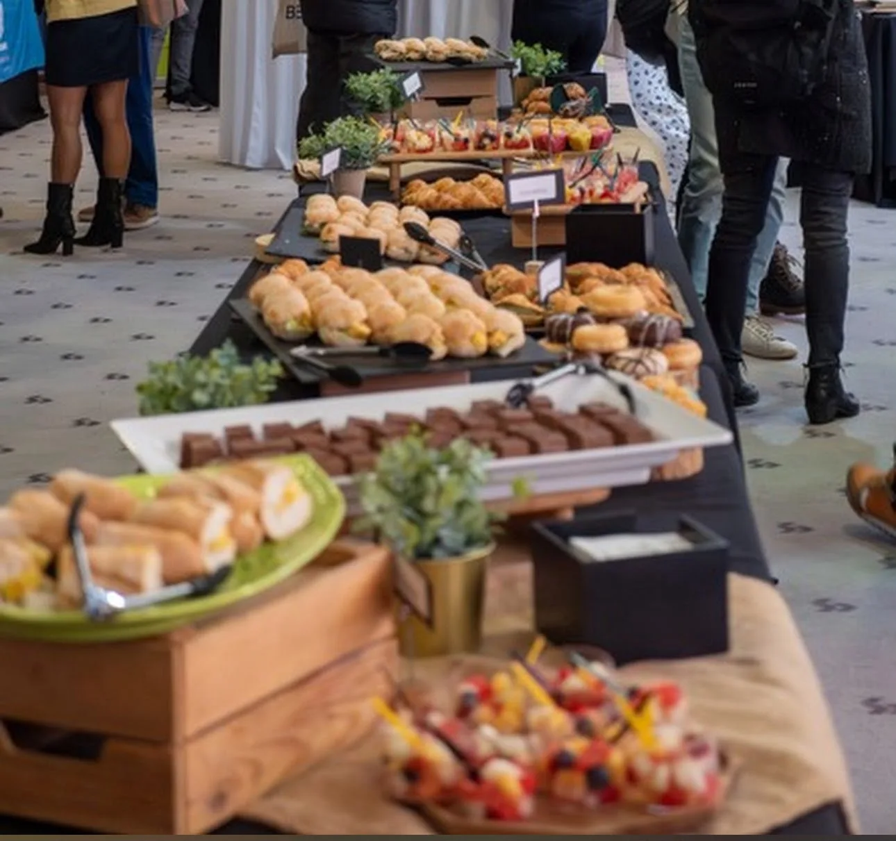Mesa de coffee break con bollería y brochetas de fruta