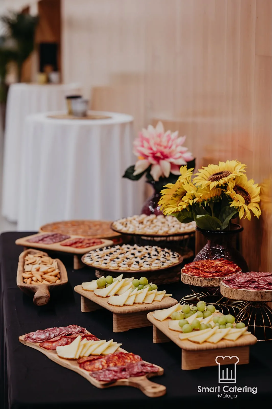 Mesa de canapés y tabla de quesos con flores