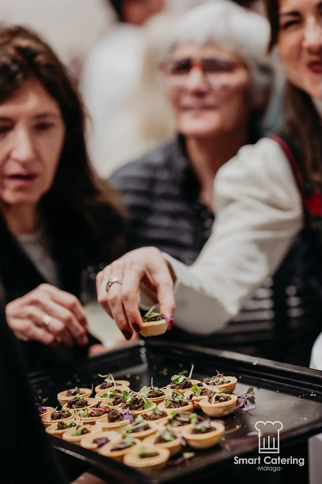 Invitados degustando tartaletas de canapé