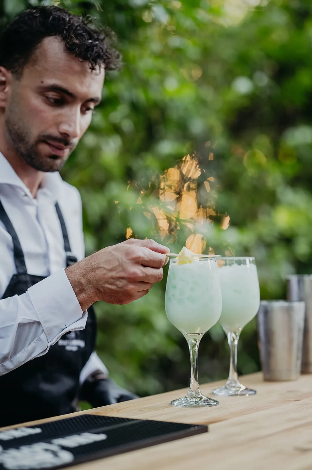 Barman de Smart Catering preparando un cóctel flambeado en una boda