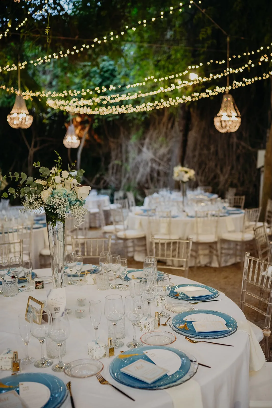 Mesa con vajilla azul, velas y candelabros de fondo, composición editorial de boda kosher