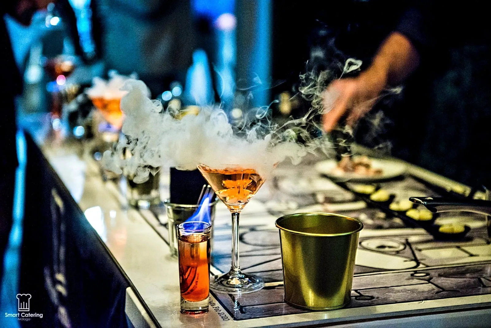 Show cooking con cóctel en llamas y logo SmartCatering, barra de evento corporativo