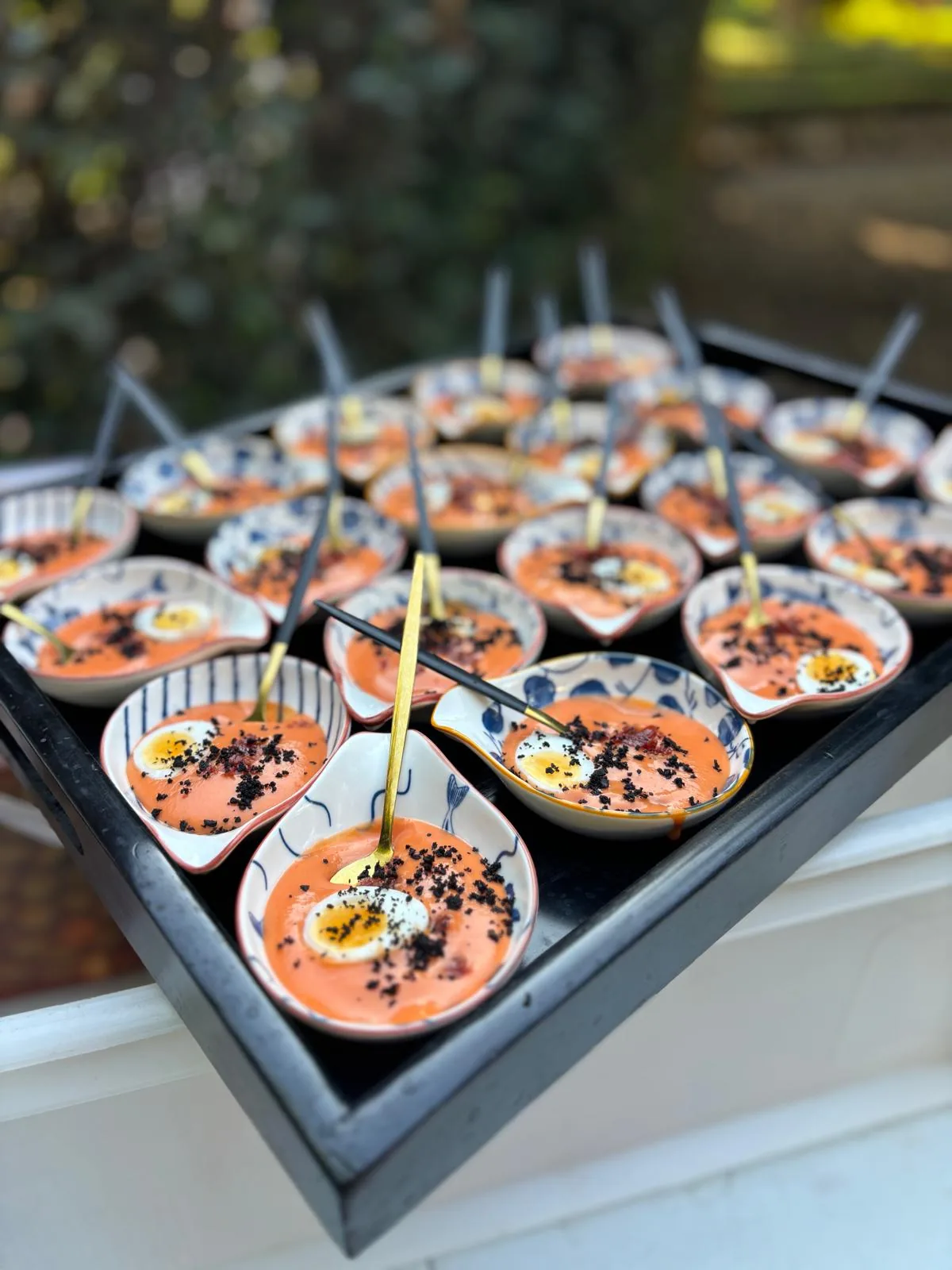 Chupitos de gazpacho con huevo de codorniz servidos en bandeja de catering