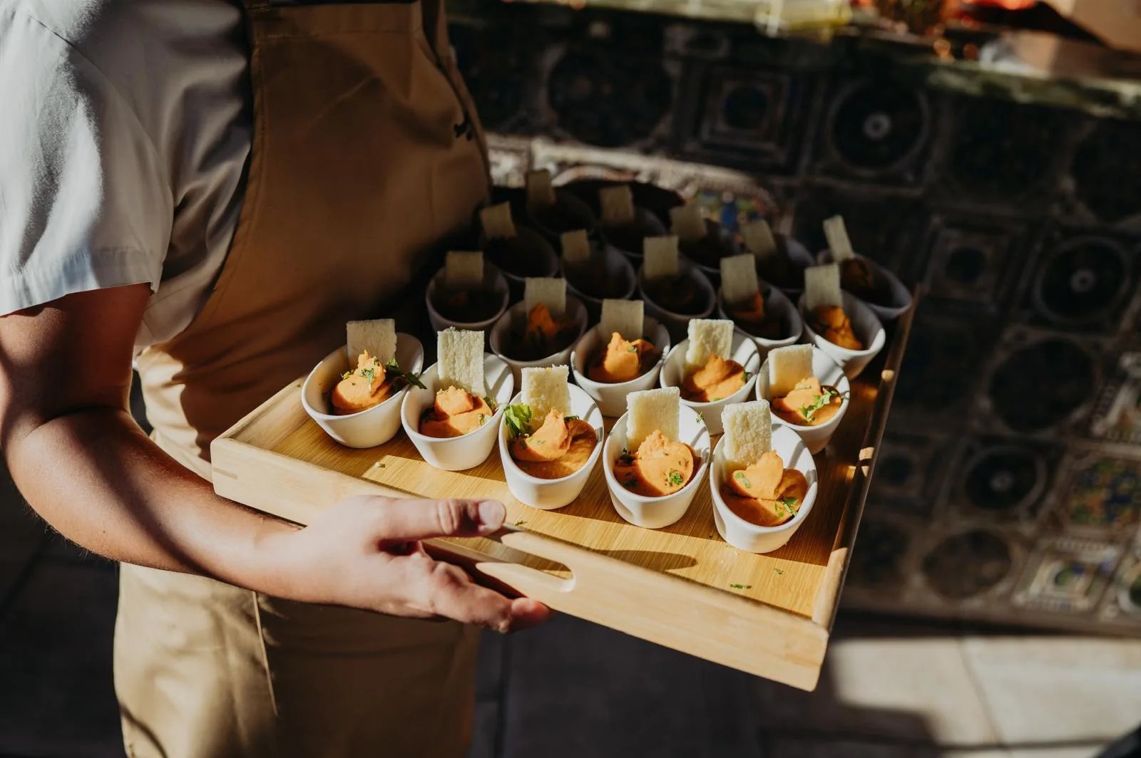 Vasitos de canapé con crema y cuña de pan tostado sobre tabla de madera
