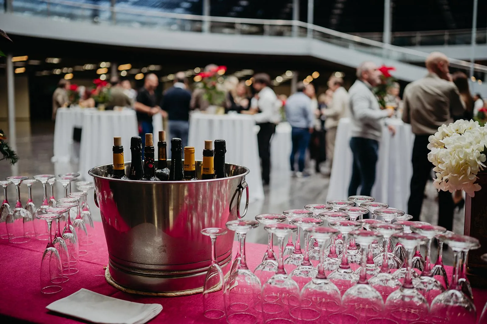 Cubo de vino en primer plano durante un cóctel con invitados de fondo